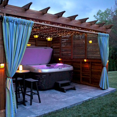 Lattice Pergola Kit (Options: 18' x 16', California Redwood, Electrical Wiring Trim for 2 Posts, 4-post Anchor Kit for High-Wind, Vertical Decorative Trims for Posts, No Ceiling Fan Base, 2 Privacy Panels [half solid wall and half louvered panel], 2 Curtain Rods, 9' Post Height, Transparent Premium Sealant). Photo Courtesy of J. Tyler of Richboro, Pennsylvania.