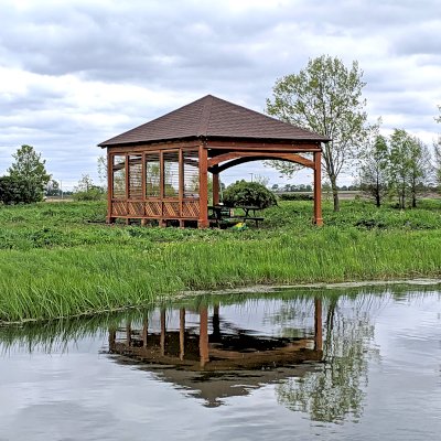 Loreto Pavilion (Options: 24' L x 18' W, 8x8 Posts, 1 Privacy Wall [Louvered with 2 ft of Lattice at the Bottom], California Redwood, 9.5' H, No Electrical Wiring Trim, 4-Post Anchor Kit for High-Wind, No Post Decorative Trim, 1 Ceiling Fan Base, 3 Curtain Rods, Transparent Premium Sealant). Photo Courtesy of D. Wisnosky of Plainfield, Illinois.