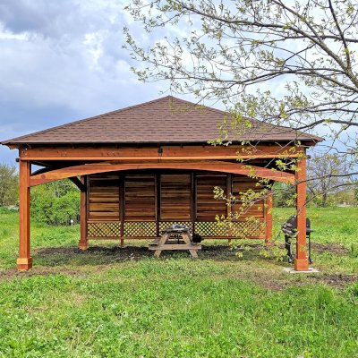 Loreto Pavilion (Options: 24' L x 18' W, 8x8 Posts, 1 Privacy Wall [Louvered with 2 ft of Lattice at the Bottom], California Redwood, 9.5' H, No Electrical Wiring Trim, 4-Post Anchor Kit for High-Wind, No Post Decorative Trim, 1 Ceiling Fan Base, 3 Curtain Rods, Transparent Premium Sealant). Photo Courtesy of D. Wisnosky of Plainfield, Illinois.