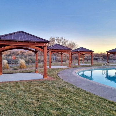 Loreto Pavilions (Options: 12' L x 12' W, California Redwood, 4 Curtain Rods, with a Ceiling Fan, 9' Post Height, Electrical Wiring Trim Kit for 4 Posts, High-Wind Post Anchor Kit, Transparent Premium Sealant). Photo Courtesy of M. Angst of Santa Ana Pue, NM.
