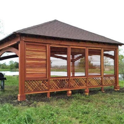 Loreto Pavilion (Options: 24' L x 18' W, 8x8 Posts, 1 Privacy Wall [Louvered with 2 ft of Lattice at the Bottom], California Redwood, 9.5' H, No Electrical Wiring Trim, 4-Post Anchor Kit for High-Wind, No Post Decorative Trim, 1 Ceiling Fan Base, 3 Curtain Rods, Transparent Premium Sealant). Photo Courtesy of D. Wisnosky of Plainfield, Illinois.