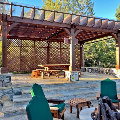 Montvale Pergolas (Options: 24' x 16', Mature Redwood, 6-Post Anchor Kit for Concrete, 1 Ceiling Fan Base and 1 T.V. Base, 2 Curtain Rods, 1 Lattice Privacy Panel, 9.5' H Posts, with Rain Guard, Coffee-Stain Premium Sealant). Photo Also Shows Some Adirondack Chairs with Ottoman. Photo Taken 1 Year After Installation, and After Restaining. Photo Courtesy of J. Brinkman of Castle Rock, Colorado.
