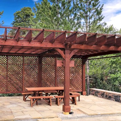 Montvale Pergolas (Options: 24' x 16', Mature Redwood, 6-Post Anchor Kit for Concrete, 1 Ceiling Fan Base and 1 T.V. Base, 2 Curtain Rods, 1 Lattice Privacy Panel, 9.5' H Posts, with Rain Guard, Coffee-Stain Premium Sealant). A Forever Picnic Table Set with Unattached Benches Shown Under the Pergola. Photo Courtesy of J. Brinkman of Castle Rock, Colorado.