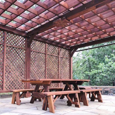 Montvale Pergolas (Options: 24' x 16', Mature Redwood, 6-Post Anchor Kit for Concrete, 1 Ceiling Fan Base and 1 T.V. Base, 2 Curtain Rods, 1 Lattice Privacy Panel, 9.5' H Posts, with Rain Guard, Coffee-Stain Premium Sealant). A Forever Picnic Table Set with Unattached Benches Shown Under the Pergola. Photo Courtesy of J. Brinkman of Castle Rock, Colorado.