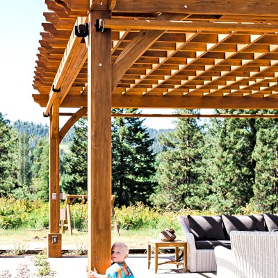 Montvale Pergolas  (Options: 22' x 22', Mature Redwood, 4-Post Anchor Kit for Concrete, Electrical Wiring Trim Kit for 4 Posts, No Ceiling Fan Base, 4 Curtain Rods, No Privacy Panels, 10' Post, Transparent Premium Sealant). Photo Courtesy of J. Scott of Coeur deline, Idaho.