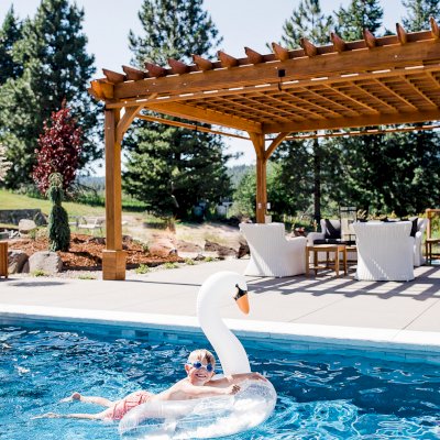 Montvale Pergolas  (Options: 22' x 22', Mature Redwood, 4-Post Anchor Kit for Concrete, Electrical Wiring Trim Kit for 4 Posts, No Ceiling Fan Base, 4 Curtain Rods, No Privacy Panels, 10' Post, Transparent Premium Sealant). Photo Courtesy of J. Scott of Coeur deline, Idaho.