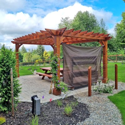 Montvale Pergola (Options: 20' x 14', Mature Redwood, 4-Post Anchor Kit for Concrete, No Ceiling Fan Base, No Curtain Rods, No Privacy Panels, 9' H Posts, Transparent Premium Sealant). Photo Also Shows a Forever Picnic Table. Photo Courtesy of R. Greenfield of Gig Harbor, Washington.