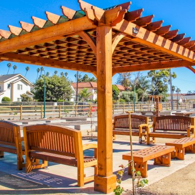 Montvale Pergolas (Options: 16' x 20', Mature Redwood, 4-Post Anchor Kit for Concrete, No Ceiling Fan Base, No Curtain Rods, No Privacy Panels, 9.5' Post, Transparent Premium Sealant). Photo also shows some Luna Memorial Benches and Lighthouse Benches. Sunbrella shade fabric above the pergola was ordered from: www.patiolane.com as a custom item. Photo Courtesy of Carpinteria Park, 5775 Carpinteria Avenue  Carpinteria, CA  93013.