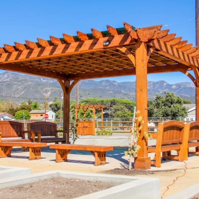 Montvale Pergolas (Options: 16' x 20', Mature Redwood, 4-Post Anchor Kit for Concrete, No Ceiling Fan Base, No Curtain Rods, No Privacy Panels, 9.5' Post, Transparent Premium Sealant). Photo also shows some Luna Memorial Benches and Lighthouse Benches. Sunbrella shade fabric above the pergola was ordered from: www.patiolane.com as a custom item. Photo Courtesy of Carpinteria Park, 5775 Carpinteria Avenue  Carpinteria, CA  93013.