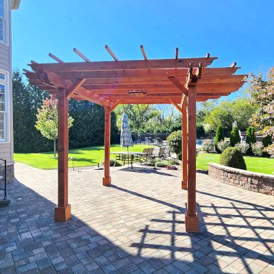 Round Pergola (Options: 16' Diameter, No Privacy Panel, California Redwood, Open Roof Slats at 18", 9ft Post Height, Include Electrical Wiring Trim for 2 Posts, 4-Post Anchor Kit for Concrete, No Post Decorative Trim, 1 Ceiling Fan Base, No Curtain Rods, Transparent Premium Sealant). Photo courtesy of J. Holobinko of Hagerstown, MD.