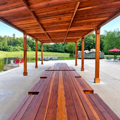 Silverado Modern Pergola (Options: 58' L, 16' W, Standard Roof Style, California Redwood, No Electrical Wiring Trim, with 1 3/4" x 11 1/4" Roof Support Timbers and 7 1/4" x 7 1/4" Posts, Post Anchor Kit for Concrete, No Privacy Panels, No Curtain Rods, 10' Post Height, Transparent Premium Sealant). Photo Also Shows 2 Maynard Modern Redwood Patio Table Sets Under the Pergola. Photo Courtesy of A. Arena of Morristown, New Jersey.