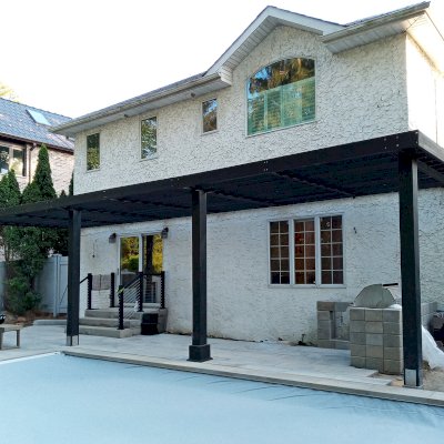 Custom Attached Silverado Modern Pergola (Options: 36' L, 10' W, Cantilevered Roof Style, 12" Roof Rafter Spacing, California Redwood, 2 Ceiling Fan Bases, 4-Post Anchor kit for Concrete, Black Stain Premium Sealant). Photo Courtesy of A. Papantomiou of Manhasset, New York.