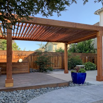 Silverado Modern Pergola (Options: 20' L, 12' W, California Redwood, Cantilevered Roof Style [3' On One Side and 2' On the Other Side], No Electrical Wiring Trim, with 1 3/4" x 9 1/4" Roof Support Timbers and 7 1/4" x 7 1/4" Posts, Roof Rafter Spacing at 6", 4 Post Anchor Kit for Concrete, No Privacy Panels, 1 Curtain Rod and 2 Fascia Boards, 9' Post Height, Transparent Premium Sealant). Photo highlights the double cantilever customization requested. Photo Courtesy of K. Maki of Oakdale, CA.