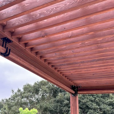 Silverado Modern Pergola (Options: 20' L, 15' W, Cantilevered Roof Style, California Redwood, No Electrical Wiring Trim, with 1 3/4" x 9 1/4" Roof Support Timbers and 7 1/4" x 7 1/4" Posts, Roof Rafter Spacing at 6", 4 Post Anchor Kit for High-Wind, No Privacy Panels, 3 Curtain Rods, 10' Post Height, Coffee-Stain Premium Sealant). Photo Courtesy of V. Weld of Morgan Hill, CA.