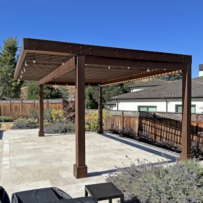 Silverado Modern Pergola (Options: 20' L, 15' W, Cantilevered Roof Style, California Redwood, No Electrical Wiring Trim, with 1 3/4" x 9 1/4" Roof Support Timbers and 7 1/4" x 7 1/4" Posts, Roof Rafter Spacing at 6", 4 Post Anchor Kit for High-Wind, No Privacy Panels, 3 Curtain Rods, 10' Post Height, Coffee-Stain Premium Sealant). Photo Taken 2 Years After Installation. Photo Courtesy of V. Weld of Morgan Hill, CA. 