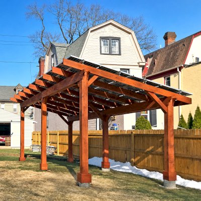 Solar Pergola (Options: 26' x 13' 8", Mature Redwood, Oversize Timbers by Custom Request, 6-Post Anchor Kit for High-Wind, Transparent Premium Sealant). Solar Panels Installed by Customer. Photo Courtesy of M. Guzzetta of Pittsburgh, Pennsylvania.