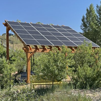 Solar Pergola (Options: 23' L x 18' W, Mosaic California Redwood, 12:7 Pitch, Post Anchor Kit for High-Wind, Transparent Premium Sealant). Pergola Installed in Colorado Mountain College in Steamboat Springs, CO.