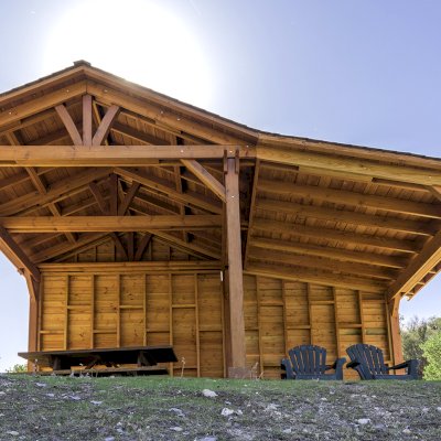 Sunset Patio Pavilion Attached to a 12' x 12' Del Norte Pavilion (Options: 9' x 12', Douglas-fir, No Ceiling Fan Base, No Electrical Wiring Trim Kit, 2-Post Anchor Kit for High-Wind, with Custom Solid Wall, Transparent Premium Sealant). Photo Courtesy of J. Randall of Warner Springs, CA.
