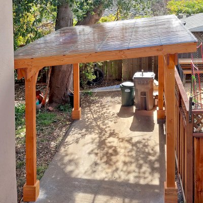 Custom Sunset Patio Pavilion (Options: 15' L x 10'-6" W, No Privacy Panels, Douglas-fir, No Electrical Wiring Trim, 4-Post Anchor Kit for Concrete, No Post Decorative Trim, with Transparent Polycarbonate Roofing Panels Instead of the Standard Roof Boards, No Ceiling Fan Base, No Curtain Rods, Transparent Premium Sealant). Photo Courtesy of L. Draper of Aptos, California.