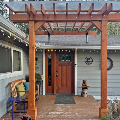 Custom Sunset Patio Pavilion (Options: 10' L x 9'-8" W, No Privacy Panels, Douglas-fir, No Electrical Wiring Trim, 2-Post Anchor Kit for Concrete, with Roof Risers by Custom Request, 10' H Posts, No Post Decorative Trim, with Transparent Polycarbonate Roofing Panels Instead of the Standard Roof Boards, No Ceiling Fan Base, No Curtain Rods, Transparent Premium Sealant). Photo Courtesy of C. Cadieux of North Bend, WA.
