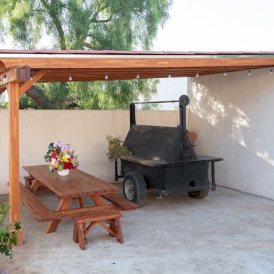 Sunset Porch Pavilion (Options: 20' x 12', Posts and Roof Timbers are Mosaic Douglas-Fir, Parquet Roofing is Mosaic Redwood, 8ft H, No Electrical Wiring Trim, 2-Post Anchor Kit for Concrete, No Post Decorative Trim, No Ceiling Fan Base, No Curtain Rods, Transparent Premium Sealant). Internal Ceiling is Our New Parquet Roofing Finish in California Redwood. Photo Also Shows a Forever Picnic Table Set in Mosaic Mature Redwood.