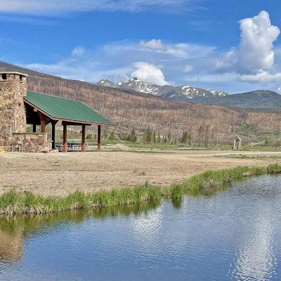 Custom Thick Timber Toledo Wood Pavilion (Options: 50' L x 24' W, Douglas-fir, 8-Post Anchor Kit for High-Wind, No Electrical Wiring Trim Kit, 10 x 8 Supports, 10 x 10 Posts & 2 x 8 Rafters, 4' Overhang by Custom Request, with 20" x 8' Cutout on the Back to Fit Fireplace, Coffee-Stain Premium Sealant). Photo Courtesy of G. Hileman of Grand Lake, Colorado.
