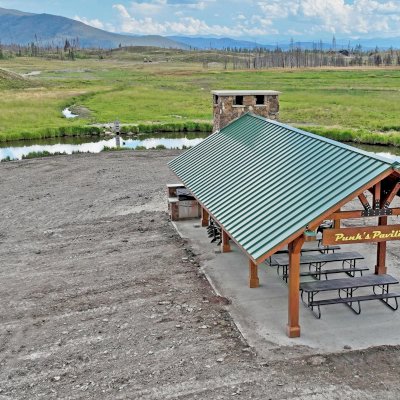 Custom Thick Timber Toledo Wood Pavilion (Options: 50' L x 24' W, Douglas-fir, 8-Post Anchor Kit for High-Wind, No Electrical Wiring Trim Kit, 10 x 8 Supports, 10 x 10 Posts & 2 x 8 Rafters, 4' Overhang by Custom Request, with 20" x 8' Cutout on the Back to Fit Fireplace, Coffee-Stain Premium Sealant). Photo Courtesy of G. Hileman of Grand Lake, Colorado.