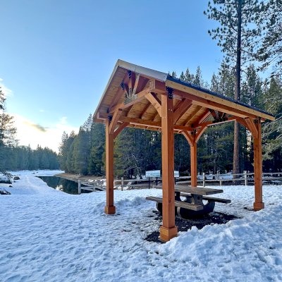 Thick Timber Toledo Wood Pavilion (Options: 16' L x 12' W, Douglas-fir, Post Anchor Kit for High-Wind, 10' H Posts, No Electrical Wiring Trims, 8x8 Posts, 8x8 Supports, 6x6 Bottom and Top Chord, 2x6 Rafters, No Fan Base, Transparent Premium Sealant). Pavilion installed in Donner Memorial State Park, 12593 Donner Pass Rd, Truckee, CA.