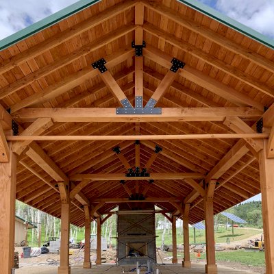 Thick Timber Toledo Wood Pavilion (Options: 50' L x 24' W, Douglas-fir, 8-Post Anchor Kit for High-Wind, with Curtain Rods, Electrical Wiring Trim for 4 Posts, 10 x 10 Supports and Posts, 8 x 8 Rafters, Transparent Premium Sealant). Custom 4' Overhang on All Sides (Standard Overhang is 1'). Photo Courtesy of R. Barry of Hayden, Colorado.
