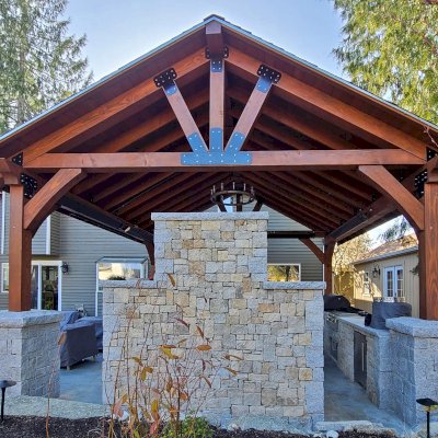 Thick Timber Toledo Wood Pavilion (Options: 20' L x 20' W, Douglas-fir, 4-Post Anchor Kit for High-Wind, 9' H Posts, 2 Electrical Wiring Trims, 8 x 8 Supports and Posts, 8 x 8 Rafters, No Fan Bases, Coffee-Stain Premium Sealant). Photo Taken After Resealed, 1 Year After Installation. Photo Courtesy of V. Dollbaum of Mill Creek, WA.