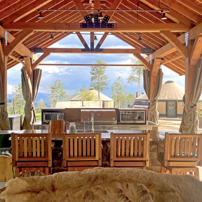 Thick Timber Toledo Wood Pavilion (Options: 50' L x 24' W, Douglas-fir, 8-Post Anchor Kit for High-Wind, with Curtain Rods, Electrical Wiring Trim for 4 Posts, 10 x 10 Supports and Posts, 8 x 8 Rafters, Transparent Premium Sealant). Custom 4' Overhang on All Sides (Standard Overhang is 1'). Photo Courtesy of R. Barry of Hayden, Colorado.