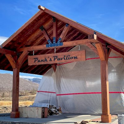 Custom Thick Timber Toledo Wood Pavilion (Options: 50' L x 24' W, Douglas-fir, 8-Post Anchor Kit for High-Wind, No Electrical Wiring Trim Kit, 10 x 8 Supports, 10 x 10 Posts & 2 x 8 Rafters, 4' Overhang by Custom Request, with 20" x 8' Cutout on the Back to Fit Fireplace, Coffee-Stain Premium Sealant). Photo Courtesy of G. Hileman of Grand Lake, Colorado.
