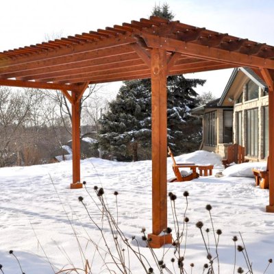 Traditional Wooden Garden Pergola (Options: 20' L x 14' W, Mature Redwood, No Electrical Wiring Trim, Slats at 6" and Rafters at 18", Lengthwise Roof Support Timbers, 4-Post Anchor Kit for Stone, No Ceiling Fan Base, No Privacy Panels, No Curtain Rods, 9' Post Height, Transparent Premium Sealant). Photo Courtesy of Mary Louise and Gerry Neugent of Des Moines, IA.
