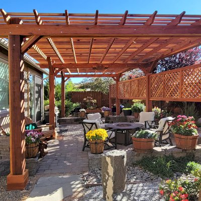 Traditional Wooden Garden Pergola (Options: Custom Size 26' 4" L x 15' W, California Redwood, Electrical Wiring Trim for 1 Post, Open Roof with Slats at 6", Rafters at 18", 6-Post High-Wind Anchor Kit, 1 Ceiling Fan Base, 3 Lattice Privacy Panels [1 Extra Post and Panel by Custom Request], No Curtain Rods, 10' Posts, Transparent Premium Sealant). Photo Courtesy of N. Moreau of Reno, NV.