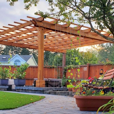 Traditional Wooden Garden Pergola (Options: 16' L x 16' W, Mosaic Redwood, Electrical Wiring Trim for 1 Post, Open Roof with Slats at 18", Rafters at 18", 2-Post Anchor Kit for Concrete, No Ceiling Fan Base, No Privacy Panels, No Curtain Rods, 9' Posts, Transparent Premium Sealant). 2 Back Posts Already Existing On Site. Photo Courtesy of J. Hawkes of Lacey, WA.
