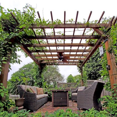 Traditional Wooden Garden Pergola (Options: 14' L x 12' W, Mature Redwood, No Electrical Wiring Trim, Open Roof with Slats at 18", Rafters at 18", Lengthwise Roof Support Timbers, 4-Post Anchor Kit for Concrete, No Ceiling Fan Base, No Privacy Panels, No Curtain Rods, 9' Post Height, Transparent Premium Sealant). Photo Courtesy of D. Vickery of St. Paul, Minnesota.