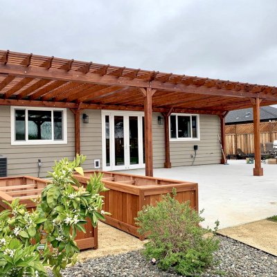 Traditional Wooden Garden Pergola (Options: 42’ L x 16’-3 1/2” W, Old-Growth Redwood by Custom Request, No Electrical Wiring Trim, Open Roof with Slats at 6", Rafters at 18", 8-Post Anchor Kit for Concrete, No Ceiling Fan Base, No Privacy Panels, No Post Decorative Trims, No Curtain Rod, 10' Post Height, Transparent Premium Sealant). Photo Courtesy of D. Menzel of Santa Rosa, CA.