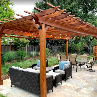 Traditional Wooden Garden Pergola (Options: 25' L x 14' W, California Redwood, Electrical Wiring Trim for 2 Posts, Open Roof with Slats at 18", with 2' Overhang by Custom Request, Rafters at 12", 4-Post Anchor Kit for High-Wind, No Ceiling Fan Base, No Privacy Panels, Curtain Rods on 2 Sides, 9.5' Post Height, Transparent Premium Sealant). Photo Also Shows a Storage Shed. Photo Courtesy of J. Lewis of Mountain View, CA.