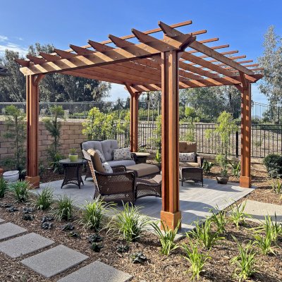 Traditional Wooden Garden Pergola (Options: 14' L x 14' W, Mature Redwood, Electrical Wiring Trim for 4 Posts, Open Roof with Slats at 18", Rafters at 18", Axis End Cut Detail, 4-Post Anchor Kit for Concrete, Vertical Post Decorative Trims, No Ceiling Fan Base, No Privacy Panels, No Curtain Rods, 9' Posts, Transparent Premium Sealant). Photo Courtesy of P. Kelley of Camarillo, California.