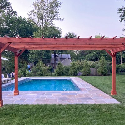 Traditional Wooden Garden Pergola (Options: 10' L x 20' W, California Redwood, Electrical Wiring Trim for 1 Post, Open Roof with Slats at 18", Rafters at 18", 4-Post Anchor Kit for Concrete, No Ceiling Fan Base, No Privacy Panels, No Curtain Rods, 9' Posts, Transparent Premium Sealant). Photo Courtesy of S. VanZanten of Greenville, Delaware.