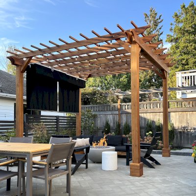 Traditional Wooden Garden Pergola (Options: 12' L x 14' W, California Redwood, Electrical Wiring Trim for 1 Post, Open Roof with Slats at 12", Rafters at 18", 4-Post Anchor Kit for Concrete, No Ceiling Fan Base, No Privacy Panels, No Curtain Rods, 10' Posts, Transparent Premium Sealant). Photo Courtesy of D. Melville of Seattle, WA.