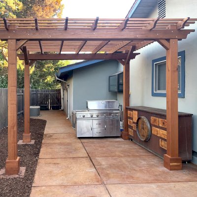 Traditional Wooden Garden Pergola (Options: 12' L x 10' W, California Redwood, No Electrical Wiring Trim, Open Roof with Slats at 6", Rafters at 18", 4-Post Anchor Kit for Concrete, No Ceiling Fan Base, No Privacy Panels, No Curtain Rods, 9.5' Posts, Transparent Premium Sealant). Photo Courtesy of C. Lowe of Davis, CA.