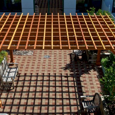 Traditional Wooden Garden Pergola (Options: 18' L x 14' W, California Redwood, No Electrical Wiring Trim, Open Roof with Slats at 12", Rafters at 18", Widthwise Roof Support Timbers, 4-Post Anchor Kit For Stone, No Ceiling Fan Base, No Privacy Panels, No Curtain Rods, 9' Post Height, Transparent Premium Sealant). Photo Courtesy of Dartmouth Hitchcock Medical Center, Lebanon.