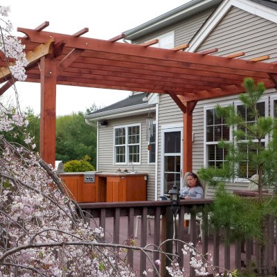 Traditional Wooden Garden Pergola (Options: 15' L x 12' W, California Redwood, No Electrical Wiring Trim, Open Roof with Slats at 18", Rafters at 18", Widthwise Roof Support Timbers, 4- Post Anchor Kit for Wood, No ceiling Fan Base, No Privacy Panels, No Curtain Rods, 9' Post Height, Transparent Premium Sealant). Photo Courtesy of Ian Clarke of Allentown, NJ.