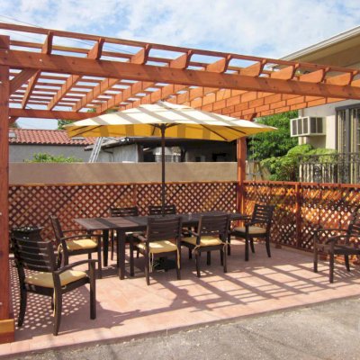 Traditional Wooden Garden Pergola (Options: 18' x 14', California Redwood, No Electrical Wiring Trim, Open Roof with Slats at 18", Rafters at 18", Lengthwise Roof Support Timbers, 4-Post Anchor Kit for Stone, No Ceiling Fan Base, 3 Privacy Panels, No Curtain Rods, 9' Post Height, Transparent Premium Sealant). Photo Courtesy of Mike W. of Los Angeles, CA.