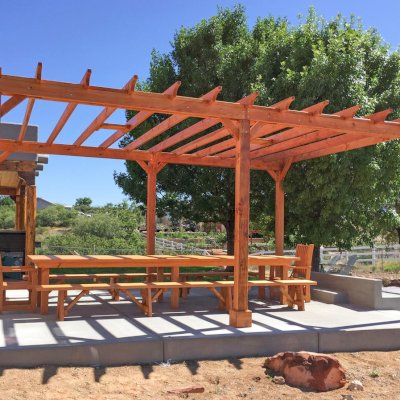 Traditional Wooden Garden Pergola (Options: 22' L x 16' W, Douglas-fir, Electrical Wiring Trim for 1 Post, Open Roof with Rafters at 18", No Slats by Custom Request, Lengthwise Roof Support Timbers, 6-Post Anchor Kit for Concrete, with 2 Ceiling Fan Bases, No Privacy Panels, No Curtain Rods, 9.5' Post Height, Transparent Premium Sealant). Photo Also Shows a San Francisco Table Set. Photo Courtesy of Chris D. of Cornville AZ.