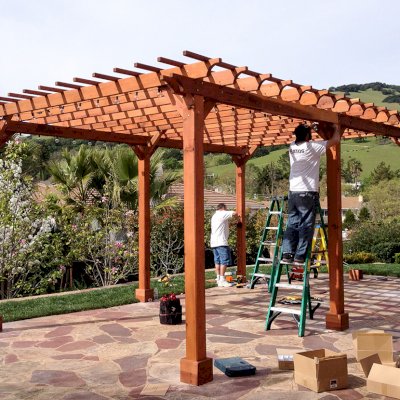 Traditional Wooden Garden Pergola (Options: 22' L x 14' W, Mature Redwood, Electrical Wiring Trim for 2 Posts, Open Roof with Slats at 6", Rafters at 18", Widthwise Roof Support Timbers, 6-Post Anchor Kit for Concrete, No Ceiling Fan Base, No Privacy Panels, No Curtain Rods, 9.5' Post Height, Transparent Premium Sealant). Photo Courtesy of Roger Cassidy of Novato, CA.