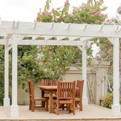 Traditional Wooden Garden Pergola (Options: 13' L x 12' W, Douglas-fir, 1 Electrical Wiring Trim, Open Roof with Slats at 6", Rafters at 18", 4-Post Anchor Kit for Concrete, No Ceiling Fan Base, No Privacy Panels, 1 Electrical Wiring Trim Kit, 9' Posts, Off-White Oil-Based Primer). Photo Also Shows a San Francisco Patio Table with Chairs in Mature Redwood. Photo Courtesy of J. Schulte of Laguna Niguel, CA.
