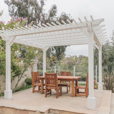 Traditional Wooden Garden Pergola (Options: 13' L x 12' W, Douglas-fir, 1 Electrical Wiring Trim, Open Roof with Slats at 6", Rafters at 18", 4-Post Anchor Kit for Concrete, No Ceiling Fan Base, No Privacy Panels, 1 Electrical Wiring Trim Kit, 9' Posts, Off-White Oil-Based Primer). Photo Also Shows a San Francisco Patio Table with Chairs in Mature Redwood. Photo Courtesy of J. Schulte of Laguna Niguel, CA.