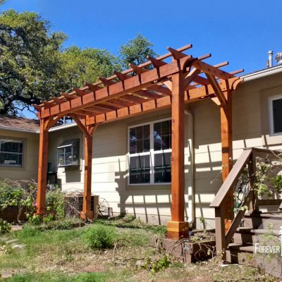 Traditional Wooden Garden Pergola (Options: 6' L x 16' W, California Redwood, No Electrical Wiring Trim, Open Roof with Slats at 18", Rafters at 18", 4-Post Anchor Kit for Concrete, No Ceiling Fan Base, No Privacy Panels, No Curtain Rods, 9' Post Height, Transparent Premium Sealant). Photo Courtesy of L. Manning of Boeme, TX.